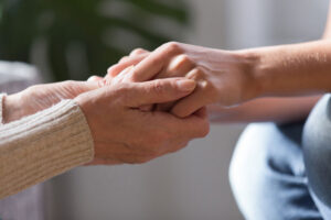 closeup of two people holding hands, representing outreach and support for people experiencing homelessness