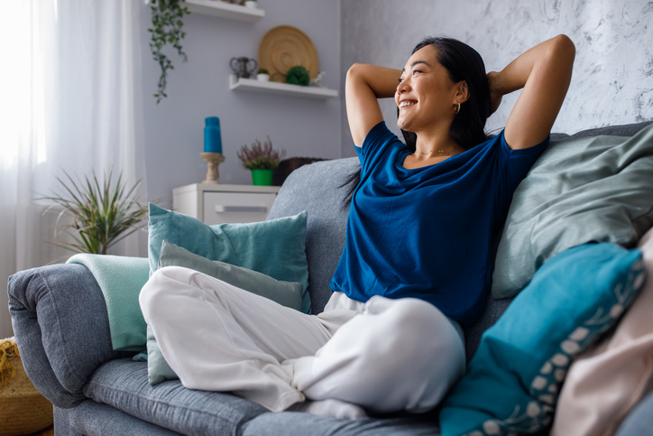 Woman lounging on sofa daydreaming